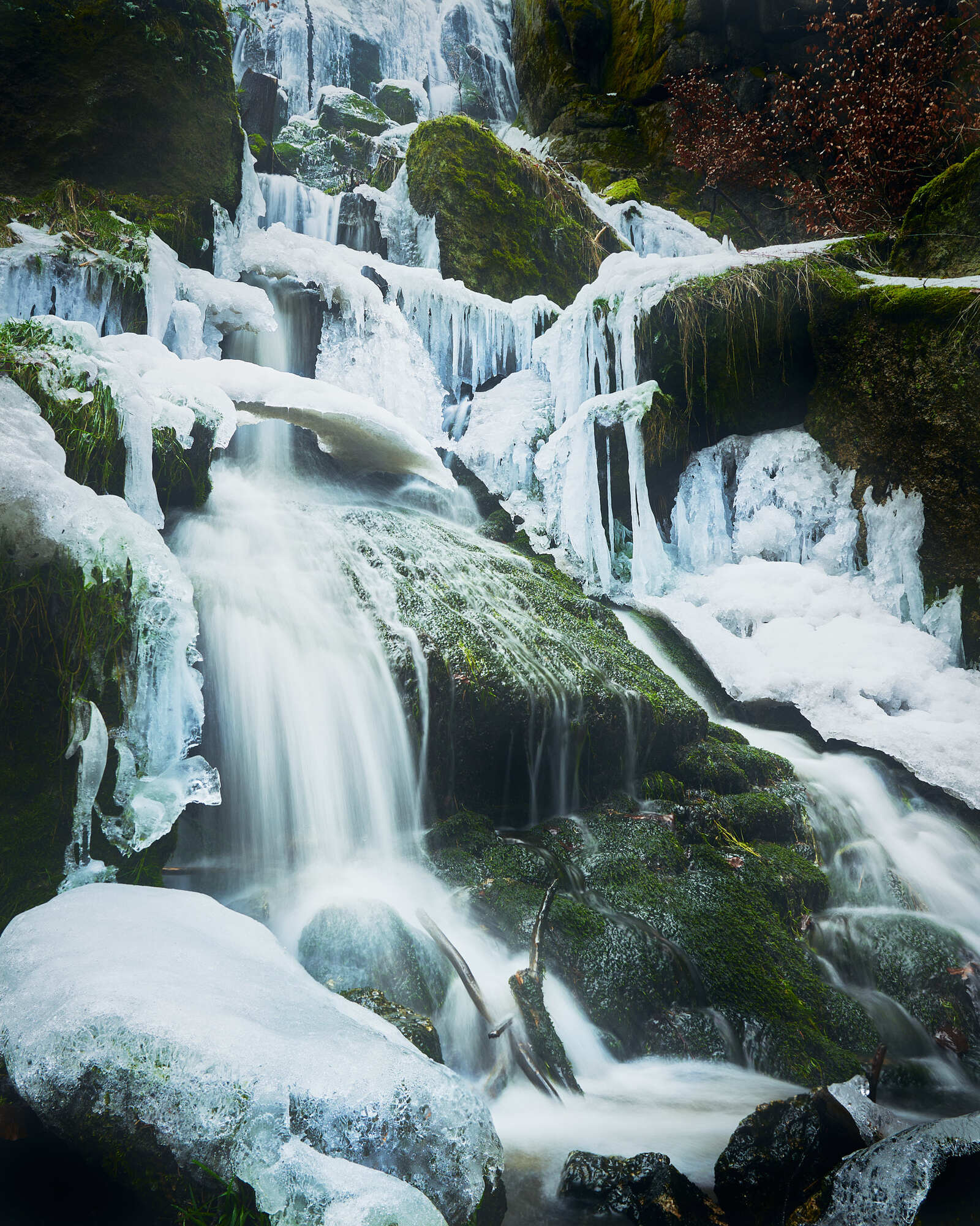 Der Blauenthaler Wasserfall im Winter 2023 teilweise gefroren und teilweise mit fließendem Wasser.